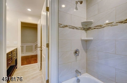 Main bath has tiled shower-over-tub with decorative tile and corner niches.
