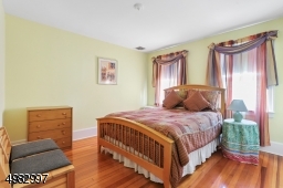 spacious bedroom, two windows, hardwood floor, closet
