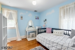 spacious bedroom, two windows, hardwood floor, closet