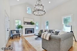 Stunning family room with vaulted ceilings, feature chandelier, fireplace and sliders to a blue stone patio overlooking a meticulously landscaped backyard and 2-car detached garage