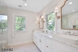 Spa-like master bath has walk-in shower with custom shower glass, 10ft double vanities, marble tile and countertops, plenty of natural sunlight and linen closet