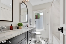 Stylish full bath with double vanities, marble countertop and linen closet