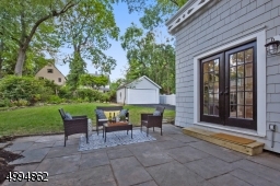 Blue stone patio overlooking a meticulously landscaped backyard and 2-car detached garage