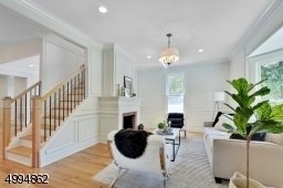 Formal living room with floor to ceiling wainscoting, original fireplace and bay window