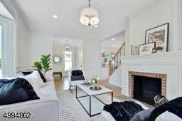 Formal living room with floor to ceiling wainscoting, original fireplace and bay window