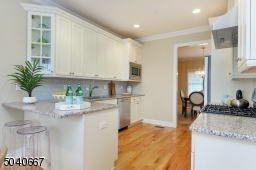 Eat-in gourmet Kitchen w/ granite countertops, subway tile backsplash, KitchenAid 5-burner gas range, oven, DW, refrigerator & microwave, SS sink w/ InSinkErator disposal & Zephyr exhaust & wood cabinetry