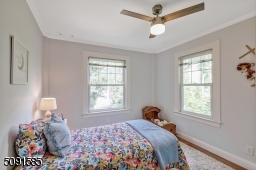 Corner bedroom with a large closet and hardwood floors.