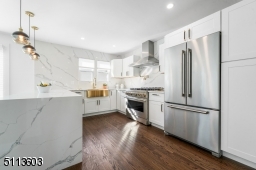 Gorgeous chef's kitchen with gold accents and beautiful quartz waterfall island and backsplash!