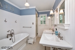 Configured from combining 2 bathrooms, this bathroom has a soaking tub, stall shower, private toilet room, twin console Kohler sinks, built-in cabinetry and shutters for privacy.