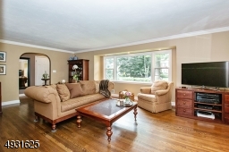 Archways, beautiful oak flooring, picture window, high hat lighting & a wood burning fireplace make the Living Room an inviting space to watch TV or read a book.