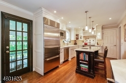 High end custom inset cabinetry, Sub Zero refrigerator & Viking appliances, center island with prep sink, and white carrera marble countertops.