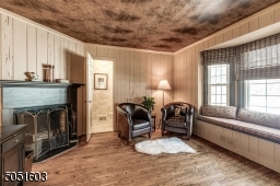 Office with wood burning fire place, hardwood floors, & powder room