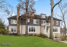 Covered front entry with Mahogany front door with decorative metal hardware featuring bead board ceiling with flush mount lantern with glass windows surrounded by sidelights and transom windows.