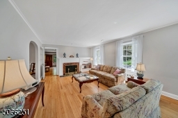 Living room w/wood burning fireplace and refinished hardwood fls.
