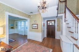 The foyer makes a wonderful first impression with lovely wallcoverings and a bold chandelier