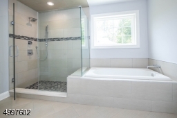 Offers a fantastic frameless glass shower and separate tub for your bathing enjoyment.