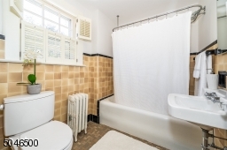 Well maintained hall bathroom with vintage tile and shower over bathtub