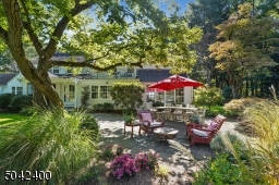 BLUE STONE PATIO SITS UNDER MATURE TREES.