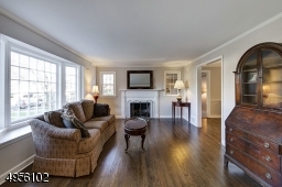 Bright Living room with wood burning  fireplace opens to formal Dining Room, entrance hall and office/den