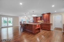 Huge center island with granite counter top. Kitchen has an abundance of cabinets.