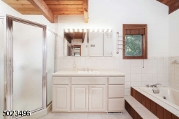 Vaulted ceiling, Jetted tub, stall shower, and large vanity w/Corian countertop.