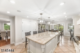 Farmhouse sink with commercial style faucet, under counter lighting and glass sliders with direct access to the deck and paver patio as well as the Dining Room