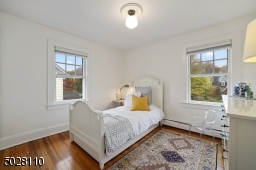 Bedroom 3 featuring hardwood floors, 2 exposures of windows and California closets