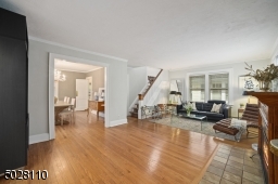 Living Room featuring hardwood floors, deep baseboard moldings, elaborate gas fireplace with stone surround and hearth