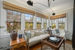 Sunroom / Office featuring hardwood floors, 3 walls of wrap around windows and modern light fixture