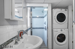 This bathroom is located off the family room. The stackable washer/dryer are included.