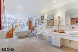 Beautiful master bath with double vanities, a luxury spa tub and over-sized walk-in shower. There is a spiral staircase that leads up into the Silo!