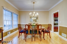 Dining Room is formal featuring custom moldings including ceiling molding, chair rail and medallion.
