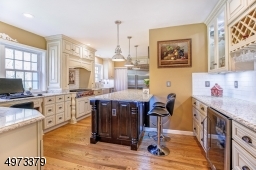 Renovated kitchen with stainless steel appliances, custom cabinetry and two breakfast bars make for easy food prep and informal dining.