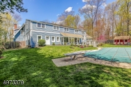 Enjoy the blue stone patio overlooking the in-ground pool on this expansive park-like property.