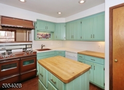 Charming kitchen with new laminated floor.. Vintage stove with double ovens & broilers. Under the cabinet lighting and plenty of cabinet space.