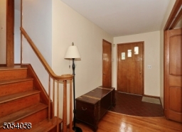 Entry hall with hardwood floor and guest closet.