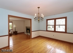 Formal dining room with chair rail and gleaming hardwood floors.