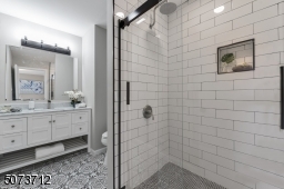 Larger vanity, full tiled shower with glass doors.