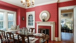 Decorative fireplace with glazed tiles & handsome mantle, built-in china cabinet, crown molding & butlers door to kitchen