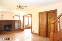 LR spans entire front of this home -- 24 ft across; hardwood floor; FPL (as is) is flanked by glass-doored built-ins and wall sconces