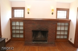 Close-up view of FPL, glass-doored built-ins, vintage windows, pair of wall sconces