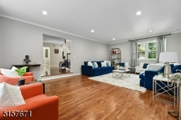 Living Room is front-to-back and step-down with deep base and crown moldings, recessed lights, triple Bay window and window seat flanked by built-ins with open shelving and lower cabinetry