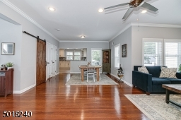 Hardwood floors, crown molding and barn door to closet