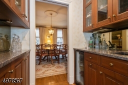 This useful entertainment center connects the kitchen with the impressive dining room.  It features a sink and beverage cooler in addition lots of space for party accessories