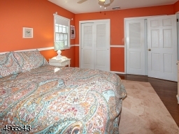 Charming bedroom with double closets, hardwood floor and paddle fan