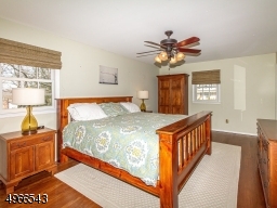 Relaxing master bedroom with walk in closet, paddle fan and hardwood floors
