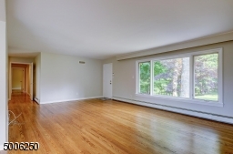 Spacious Living Room is highlighted by a triple window, wood floor - offers access to back patio.