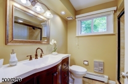 Attractive redone Master bath with wood vanity, tiled floor.