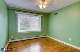 Spacious 3rd bedroom with wood floor, newer window, closet and ceiling fan.