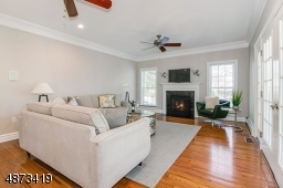 Large Family Room with gas fireplace, featuring new black granite surround, freshly painted walls.
